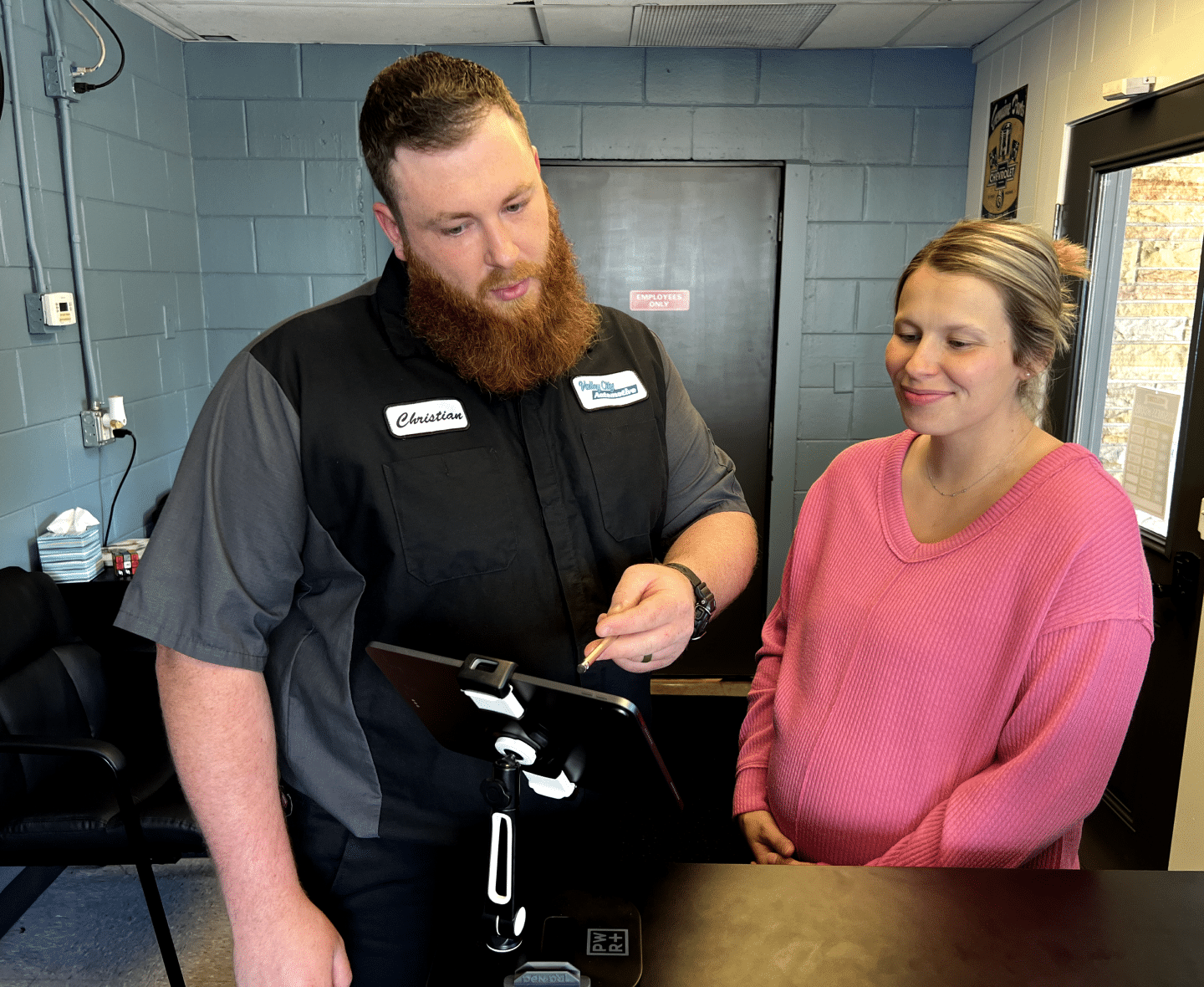 Valley City Automotive in Eau Claire, WI. A mechanic talking to a pregnant woman.