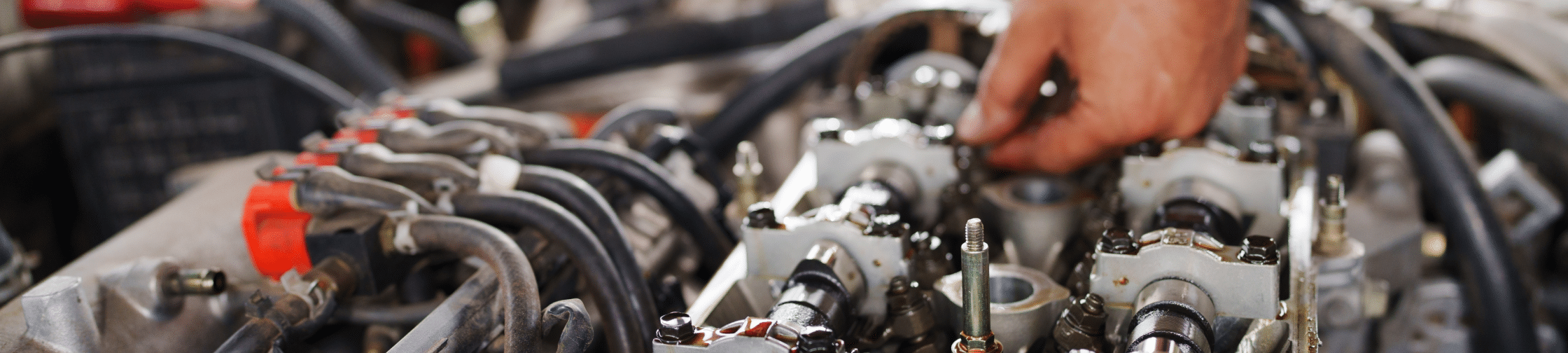 engine diagnostics and repair in Eau Claire, WI, Valley City Automotive. A close image of a mechanic's hand and vehicle's engine bay.