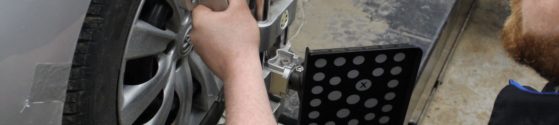 Wheel alignment in Eau Claire, WI at Valley City Automotive. A close up image of a mechanic doing wheel alignment service for a vehicle.