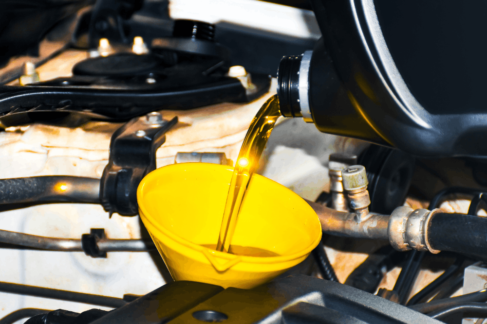 Oil change in Eau Claire, WI by Valley City Automotive. Image of fresh engine oil being poured through a funnel during routine vehicle maintenance to support engine performance and longevity.