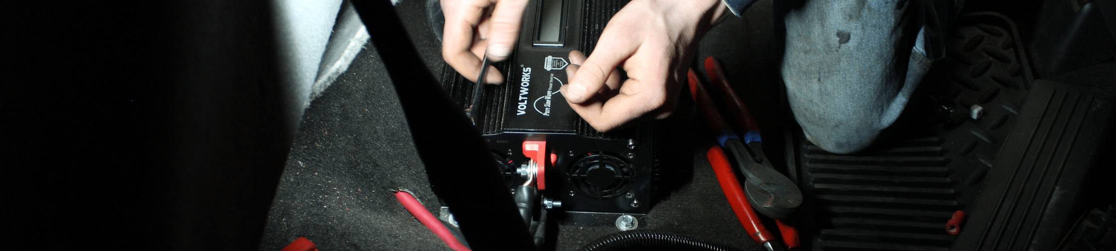 Auto Electrical Repair in Eau Claire, WI At Valley City Automotive. Technician wiring an aftermarket power inverter during auto electrical service